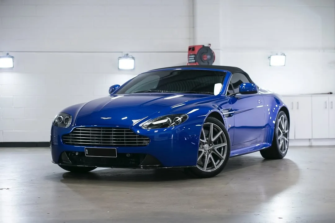 A blue Aston Martin V8 Vantage roadster in the studio