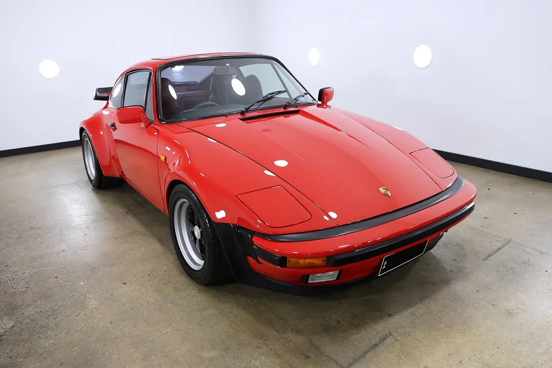 A red Porsche 930 with a slant nose front end in the studio