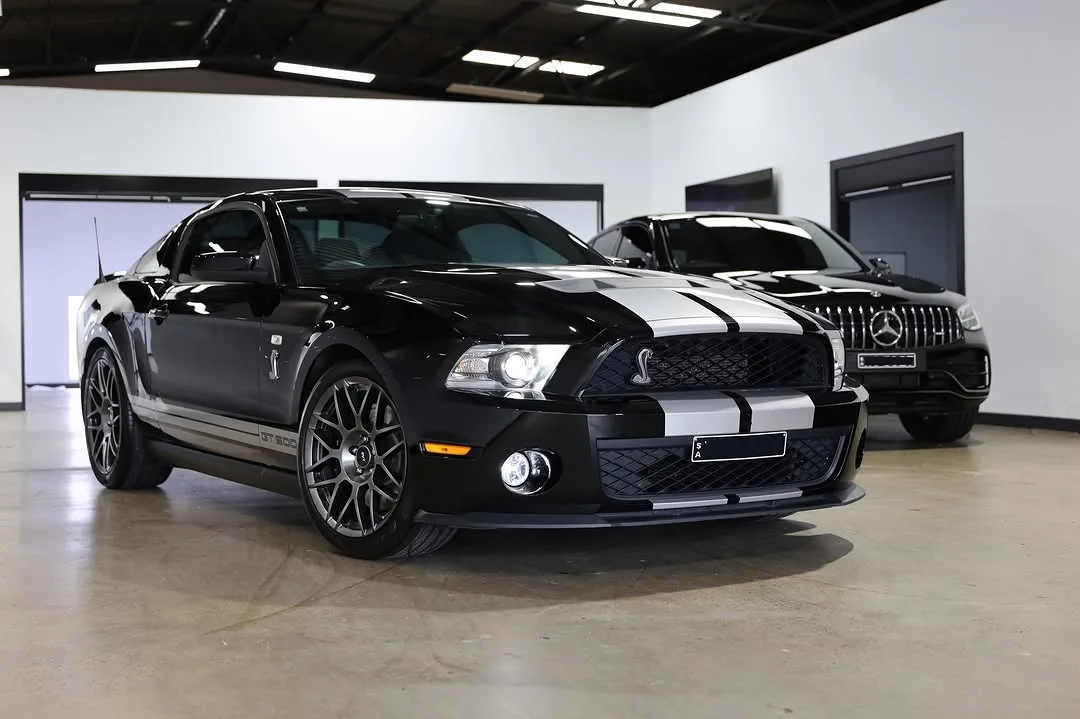 A black Shelby GT500 with silver stripes in the studio